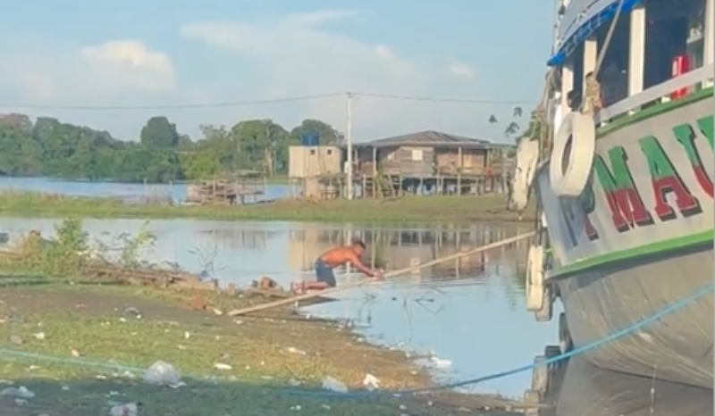 Homem sobe rampa de barco de joelhos durante festa em Autazes
