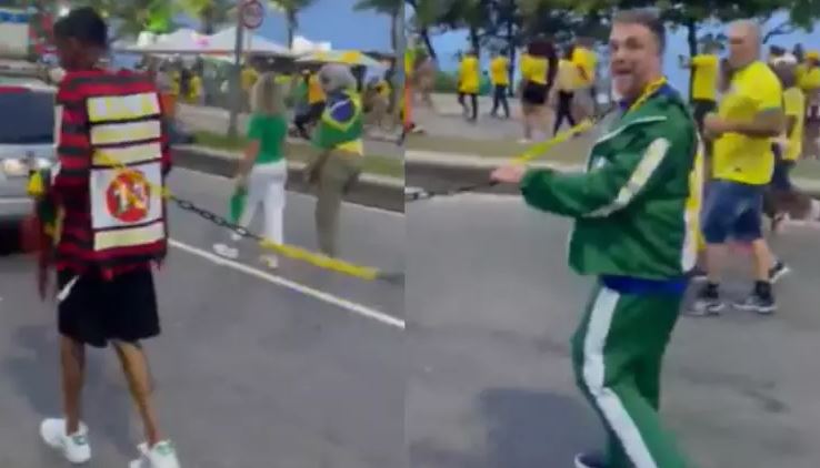 Homem branco conduz homem negro acorrentado em manifestação na Barra da Tijuca